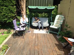 zwei Frauen sitzen in einem Pavillon auf einem Deck in der Unterkunft Lilac Farm Cottage in Collingham + 5 Fotos