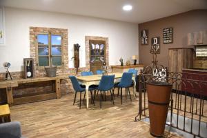 a dining room with a table and blue chairs at La Cave Secrète in Verdun-sur-Meuse