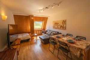 uma sala de estar com uma mesa e um sofá em Apartamentos Formigal em Formigal
