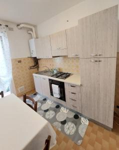 a kitchen with white cabinets and a stove top oven at La Brezza di lago in Baveno +15 photos