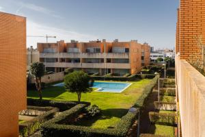 アプーリアにあるappartement tout confort dans résidence privéeの庭園とスイミングプールのある建物を望めます。