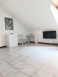 a white room with a flat screen tv and a table at La Brezza di lago in Baveno