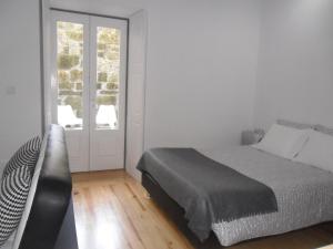 une chambre blanche avec un lit et une fenêtre dans l'établissement Your Place Porto II, à Porto