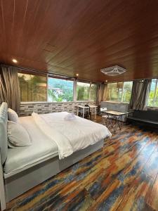 a bedroom with a large bed in a room with windows at Misty Palace Luxury Villa by Natura Stays in Lonavala +56 photos