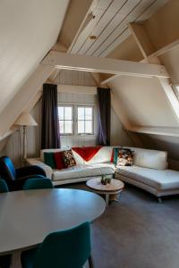 a living room with couches and tables in a attic at Appartement Parkweg in Bergen aan Zee