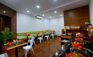 a dining room with a long table and chairs at TreeHouse Neptune Inn in Panaji +3 photos