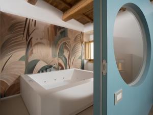 a bathroom with a white bathtub and a wall mural at Ascesi Resort in Assisi +55 photos