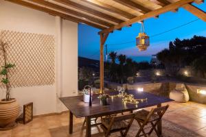 an outdoor dining area with a wooden table and chairs at Villa Maria Syros in Posidhonía