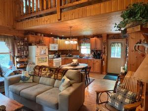 a living room with a couch and a kitchen at Camp Quityerbellyachin in Greenville