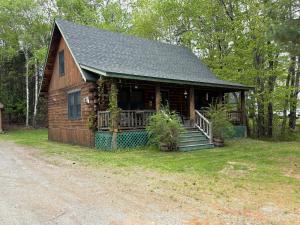 een blokhut met veranda en trap in de tuin bij Camp Quityerbellyachin in Greenville