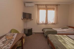 a room with two beds and a television in it at Dwór Na Otulinie in Białowieża