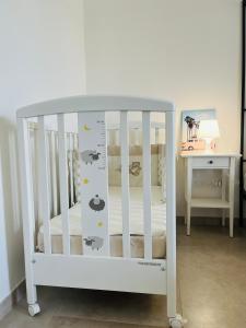 a white crib in a room with a table at Appartamento a Pula in Pula