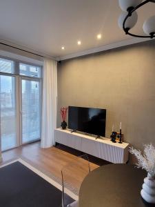 a living room with a flat screen tv on a wall at Апартаменты Luxe в центре города in Kokshetau