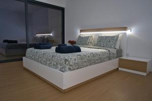 ein Schlafzimmer mit einem großen Bett mit blauen Kissen darauf in der Unterkunft Casa PoliDouro - Vila Marim in Vila Marim
