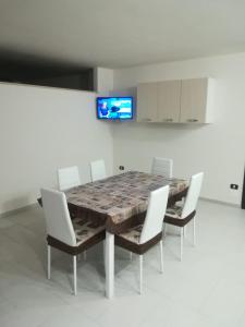 a dining room with a table and chairs and a tv at Casa Vacanza Don Carmelo in Marina di Ascea