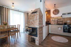 a kitchen and dining room with a brick fireplace at Family HOUSE in Witów