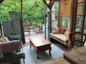 a screened in porch with a couch and a coffee table at Yourte dans la forêt in Rennes-les-Bains