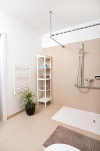 baño blanco con lavabo y planta en Augarten Apartments, en Viena