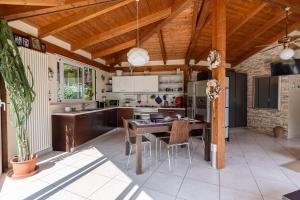 a kitchen with a wooden ceiling and a table and chairs at Blue Moon Relais in Santa Maria di Scacciano