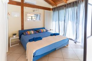 a bedroom with a blue bed and a large window at Blue Moon Relais in Santa Maria di Scacciano +55 photos