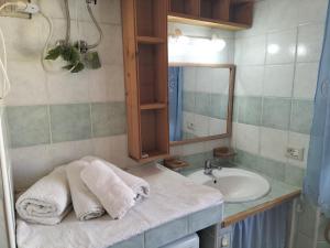 a bathroom with a sink and a mirror and towels at The square in Orosei