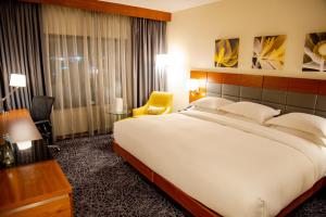 a hotel room with a large bed and a desk at Hilton Garden Inn Nairobi Airport in Nairobi