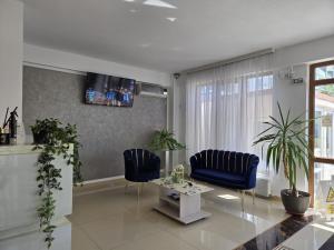 a living room with two blue chairs and a table at Armsea Mamaia Nord in Mamaia Sat/Năvodari