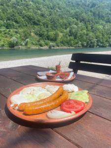a plate of food with sausage and vegetables on a table at Drinsko Srce Tegare in Bratunac +9 photos