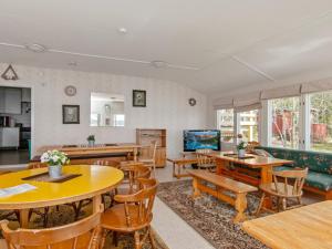 a living room with wooden tables and chairs at Holiday Home Saunamäki by Interhome in Arpolahti
