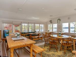 a dining room with tables and chairs and windows at Holiday Home Saunamäki by Interhome in Arpolahti
