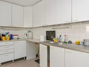 a kitchen with white cabinets and a sink at Holiday Home Saunamäki by Interhome in Arpolahti