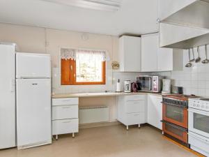 a kitchen with white appliances and a window at Holiday Home Saunamäki by Interhome in Arpolahti