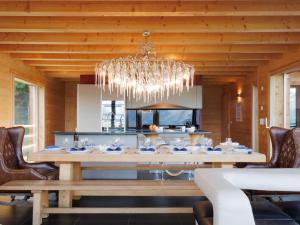a dining room with a table and a chandelier at Chalet Woovim 8 by Interhome in Nendaz