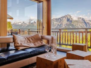 a living room with a couch and two wine glasses at Chalet Woovim 8 by Interhome in Nendaz