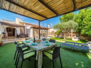 een patio met een tafel en stoelen op het gras bij Villa Villa Rosa by Interhome in Port d'Alcudia