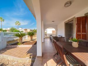 een patio met een houten tafel en stoelen bij Villa Villa Rosa by Interhome in Port d'Alcudia