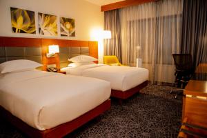 a hotel room with two beds and a desk at Hilton Garden Inn Nairobi Airport in Nairobi