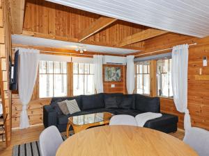 ein Wohnzimmer mit einem blauen Sofa und einem Tisch in der Unterkunft Holiday Home Saukonpiilo 1 by Interhome in Pyhätunturi