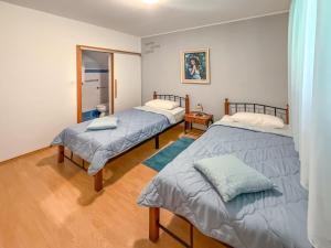 a room with two beds and a mirror at Apartment Cvjetko by Interhome in Rakalj