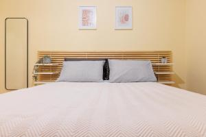 a bedroom with a white bed with two pillows at Centaurus Apartment in Old Town with a big Terrace ! in Thessaloniki
