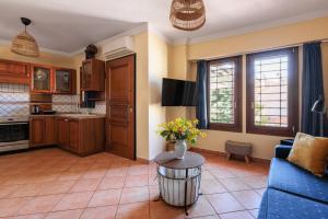 a kitchen and living room with a vase of flowers on a table at Centaurus Apartment in Old Town with a big Terrace and view to Olympus Mountain ! in Thessaloniki