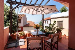 a patio with a table and an umbrella at Centaurus Apartment in Old Town with a big Terrace ! in Thessaloniki