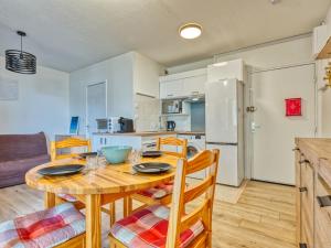 a kitchen and dining room with a wooden table and chairs at Apartment Les Terrasses de l'Atlantique-7 by Interhome in Lacanau-Océan
