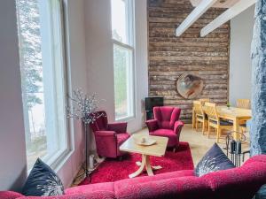 ein Wohnzimmer mit Sofa, Stühlen und einem Tisch in der Unterkunft Holiday Home Huvila lomaonni by Interhome in Kolinkylä