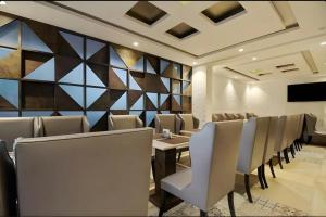 a dining room with chairs and a wall of mirrors at FabHotel Prime Supreme Grande - 600M From Calangute Beach in Calangute