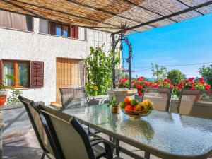 a table with a bowl of fruit on a patio at Holiday Home Lorena by Interhome in Raša