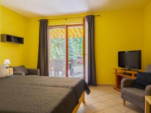 sypialnia z łóżkiem i telewizorem oraz patio w obiekcie Apartment Jókai by Interhome w mieście Balatonszárszó