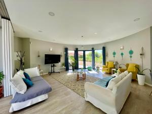 a living room with two couches and a tv at Villa Atitudo Nature in Portimão