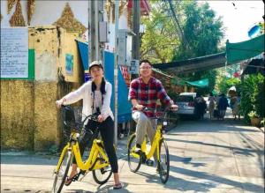 a man and a woman riding bikes down a street at Papaya House Bangkok - Wat Arun in Bangkok Noi +62 photos