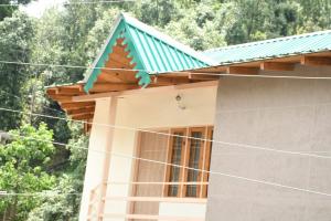 a small house with a green roof at Negi Hotel in Mukteshwar